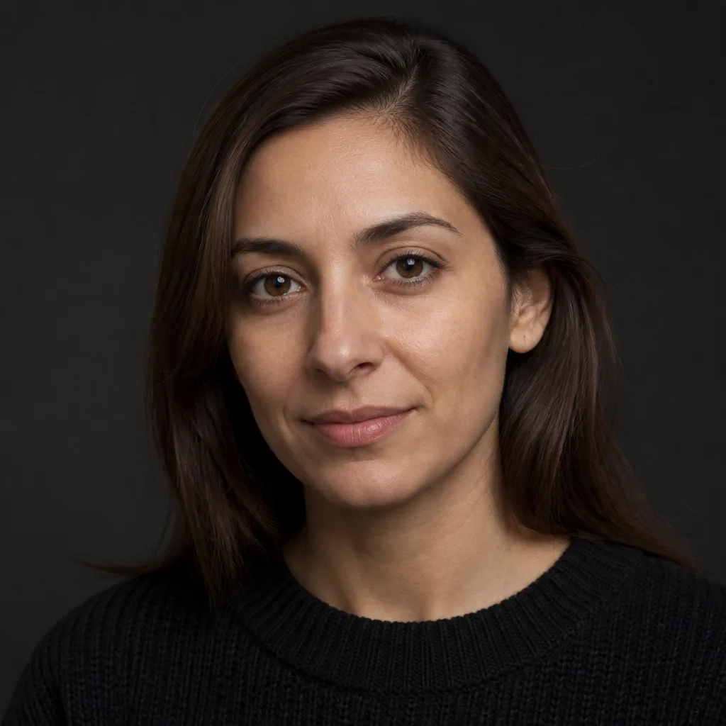 Portrait of Noor, an ecommerce operator, in a black sweater against a dark studio background
