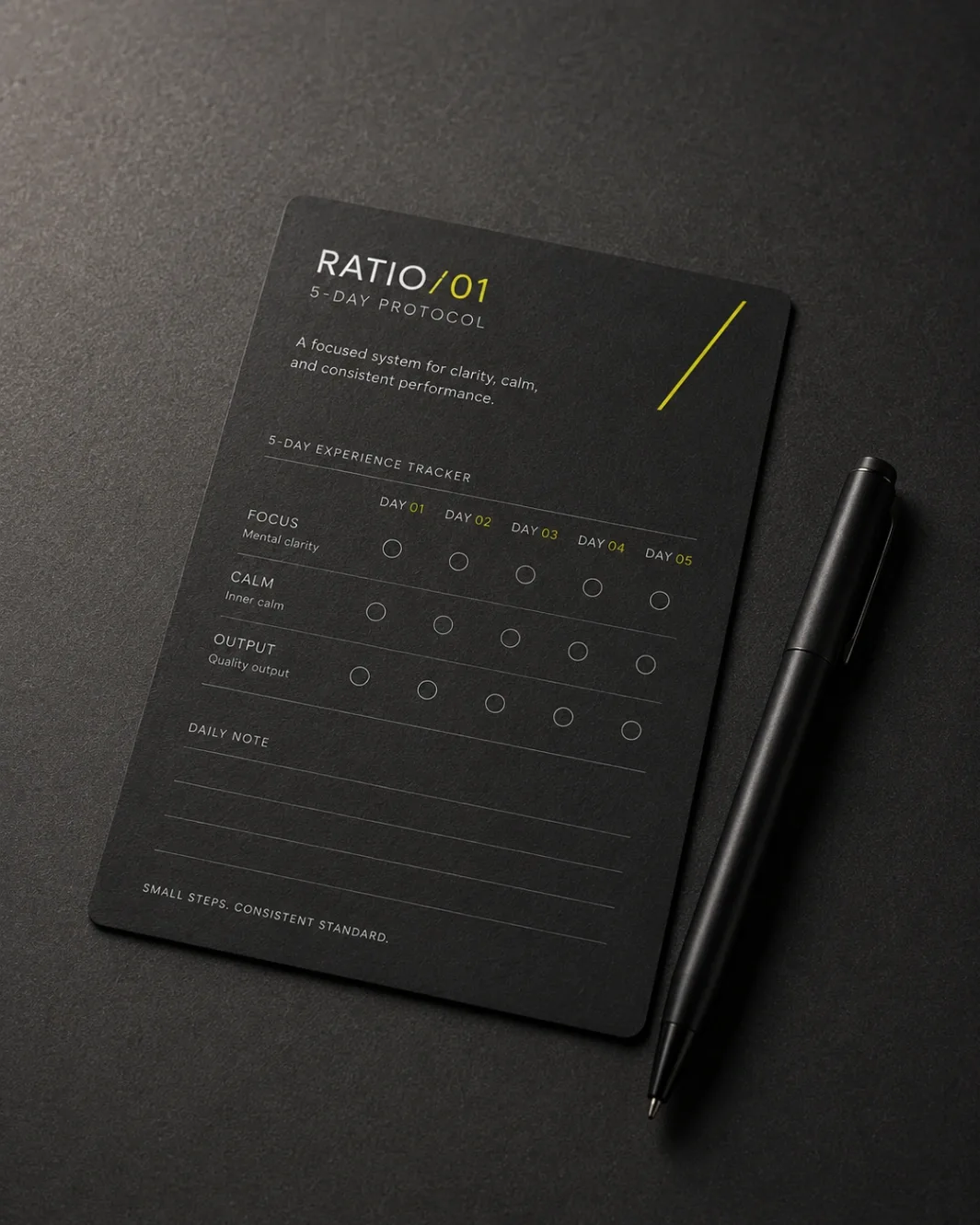 The RATIO/01 5-Day Protocol card on graphite with a black pen: FOCUS, CALM and OUTPUT rows scored across day 01 to day 05, daily note lines below